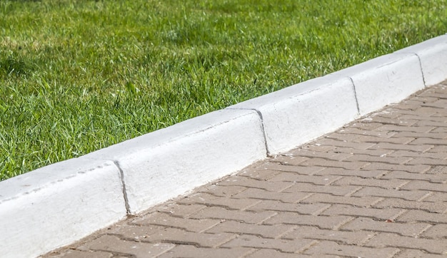 Whitewashed concrete curb in the park closeup