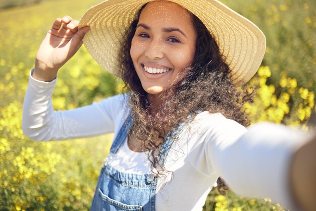 Who said country girls arent living the life. Shot of a young woman taking a selfie while surrounded by yellow flowers.