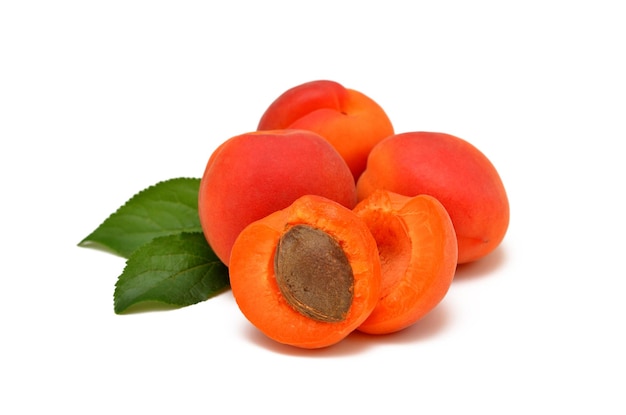 Whole apricot fruit and two halves with leaves isolated on white background