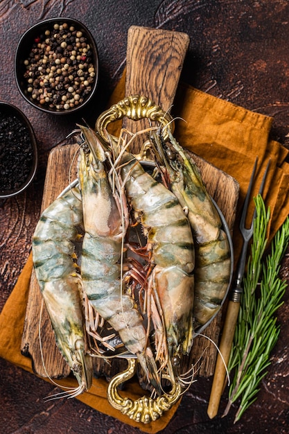 Whole Black tiger giant prawns shrimps in a skillet. Raw Seafood. Dark background. Top view.