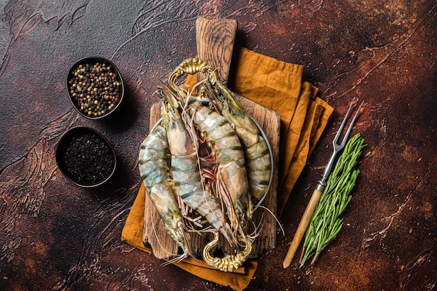 Whole Black tiger giant prawns shrimps in a skillet. Raw Seafood. Dark background. Top view.