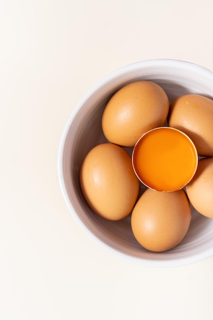 Whole eggs egg yolk and one broken isolated on a white background Top view Place for text