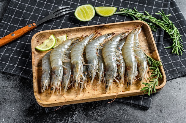 Whole fresh raw langoustine prawns, shrimps on a wooden tray. Top view