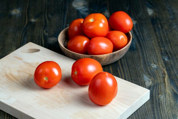 Whole fresh tomatoes in a wooden bowl