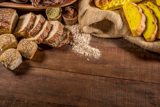 Whole grain bread on rustic wooden table with ingredients in background top view copy space