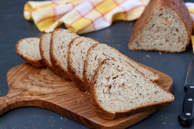 Whole grain carrot bread with flax seeds, located on a wooden board