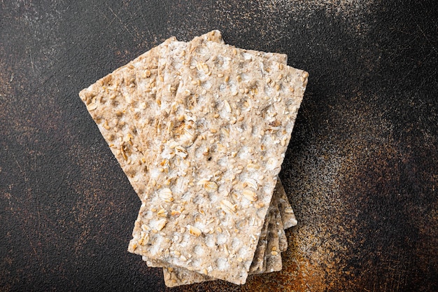 Whole grain crisp bread set, on old dark rustic table, top view flat lay