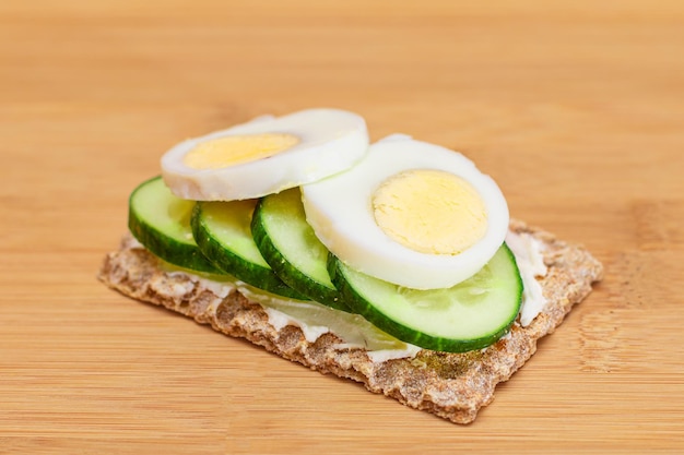 Whole grain crispbread with fresh cucumber egg cream cheese and radish