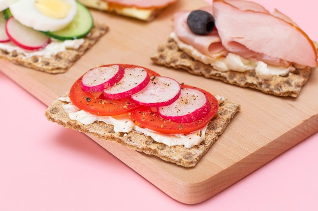 Whole grain crispbread with ham tomato radish cucumber and cheese