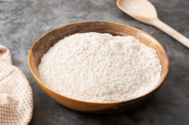 Whole grain flour in wooden bowl. Baking ingredient for pastry and bread.