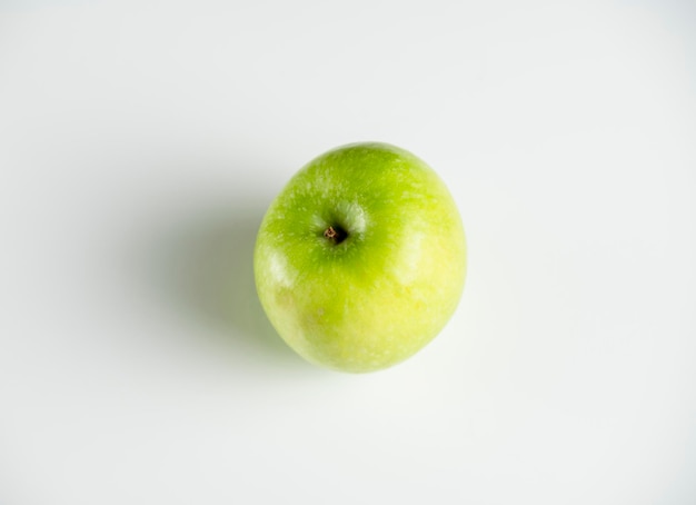 A whole green apple on a white background