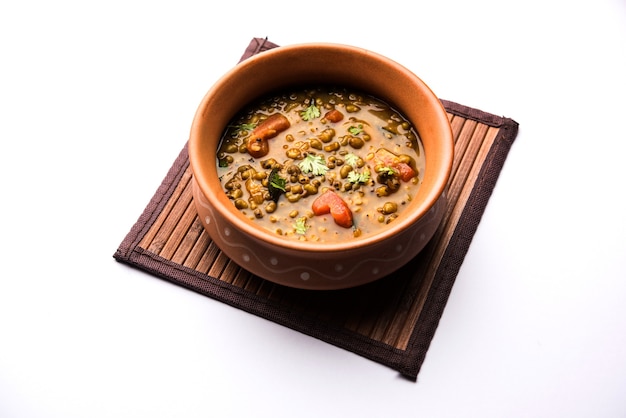 Whole Green Moong Dal fry or Whole Mung bean Tadka served in a bowl. selective focus