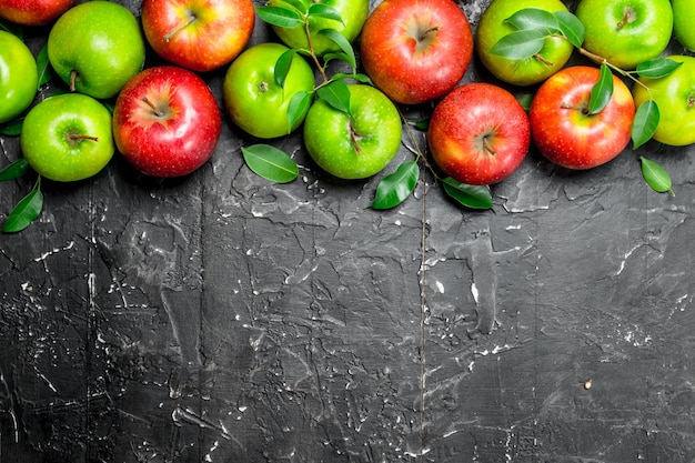 Whole green and red apples with leaves