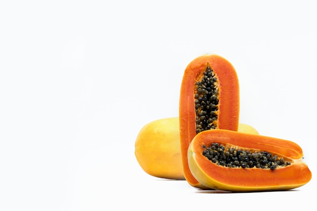 Whole and half of ripe papaya fruit with seeds isolated