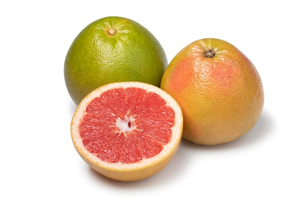 Whole and halved red juicy grapefruit close up on white background