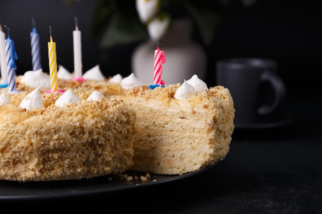 Whole holiday cake with crumbly shortcrust pastry and mini meringue Birthday cake with extinguished candles Homemade baking Black background selective focus closeup