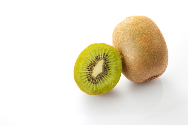 Whole kiwi fruit and his sliced segments on white background