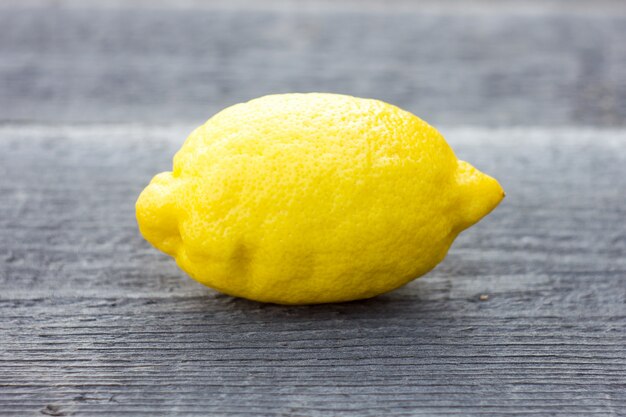 Whole lemon on wooden background.