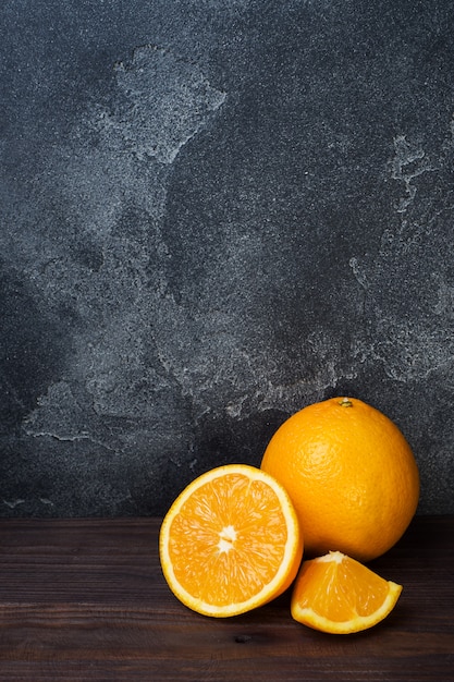 whole orange and slices on wooden table