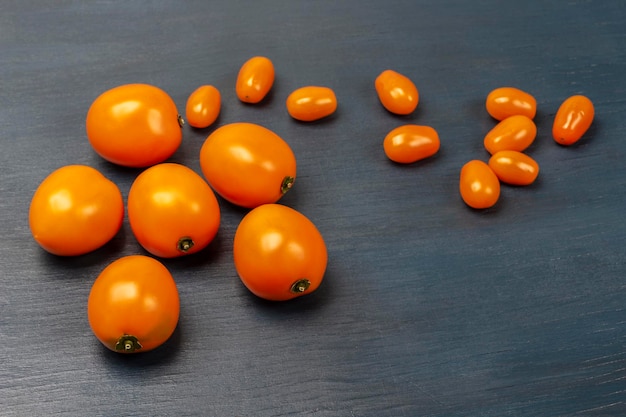 Whole orange tomatoes on a blue background