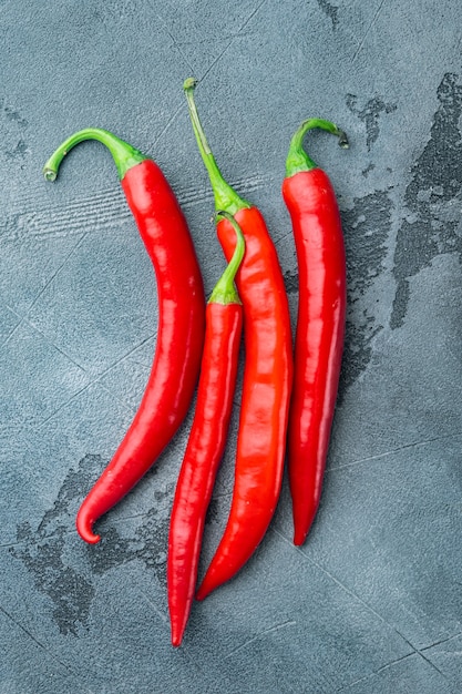 Whole red chili peppers set, on gray table, top view or flat lay