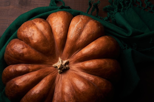 Whole ripe orange pumpkin close up wooden background