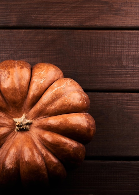 Whole ripe orange pumpkin close up wooden background