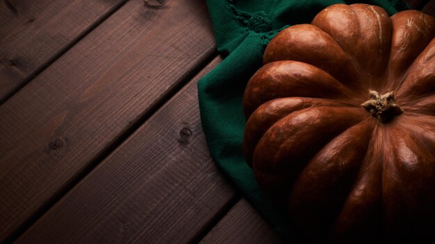 Whole ripe orange pumpkin close up wooden background