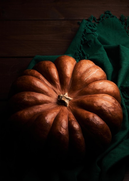 Whole ripe orange pumpkin close up wooden background