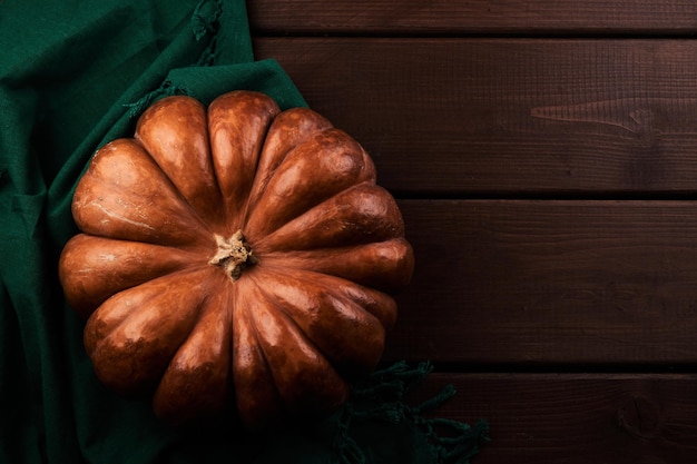 Whole ripe orange pumpkin close up wooden background