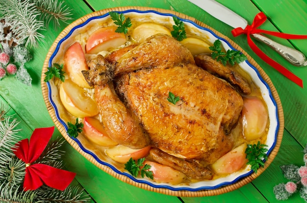 Whole roast chicken stuffed with apples, in a creamy sauce and slices of apples. Christmas dinner