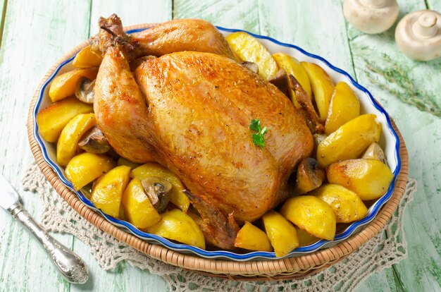 Whole roasted chicken with potatoes and mushrooms