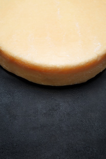 Whole round Head of parmesan or parmigiano hard cheese on concrete space