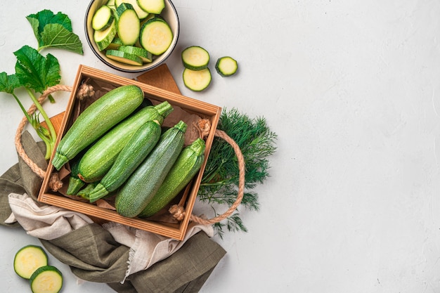 Whole and sliced zucchini on a gray background with space for copying. Top view. Natural, healthy food.