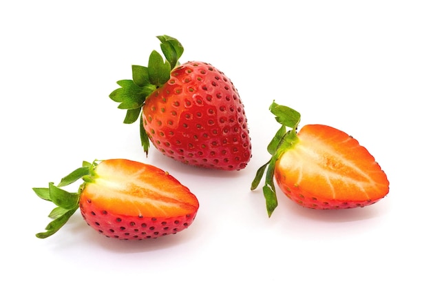 Whole strawberry and halved strawberry on white isolated background