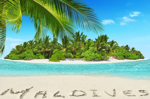 Whole tropical island within atoll in tropical Ocean. Uninhabited and wild subtropical isle with palm trees. Inscription "Maldives" in the sand on a tropical island,  Maldives.