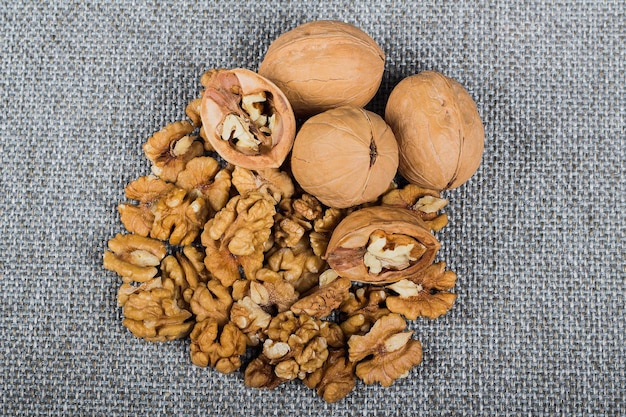 Whole walnuts and kernels on burlap background healthy food