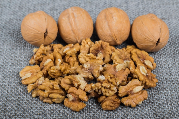 Whole walnuts and kernels on burlap background healthy food