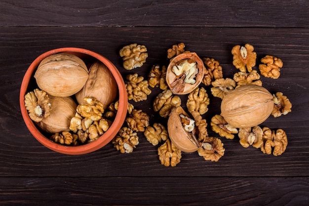 Whole walnuts and kernels on wooden background walnut on a dark old table in a clay pot