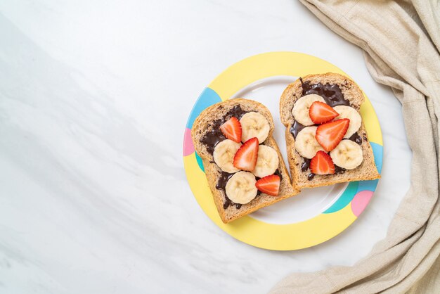 whole wheat bread toasted with fresh banana, strawberry and chocolate for breakfast