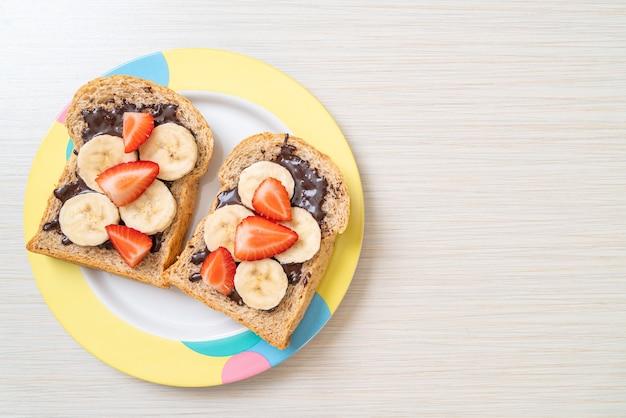 whole wheat bread toasted with fresh banana, strawberry and chocolate for breakfast