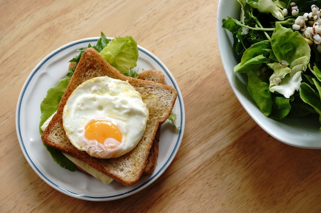 Whole wheat sandwich with eggs, fresh vegetables, ham and cheese, healthy breakfast for a new day that is happy and healthy.