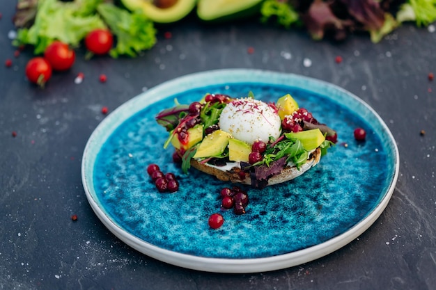 Whole wheat toasted bread with avocado poached egg soft cheese and mix salad Healthy diet food breakfast