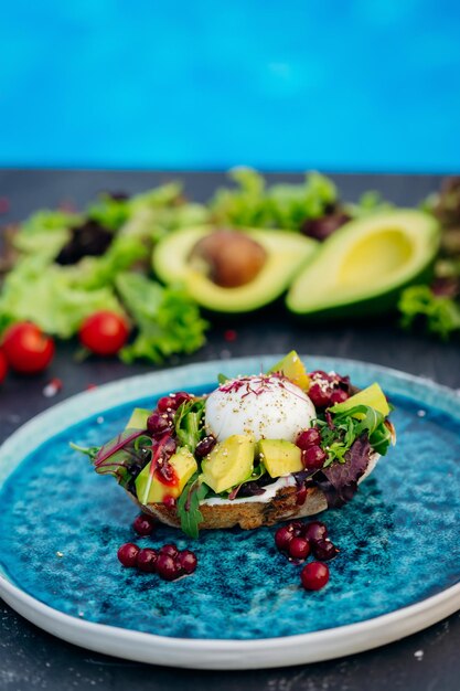 Whole wheat toasted bread with avocado poached egg soft cheese and mix salad Healthy diet food breakfast