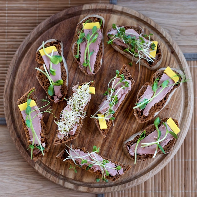 Wholegrain sandwiches with micro greens. Vegan party food table with organic vegetables canapes. Healthy lifestyle, modern cooking ingredients and eating right concept.