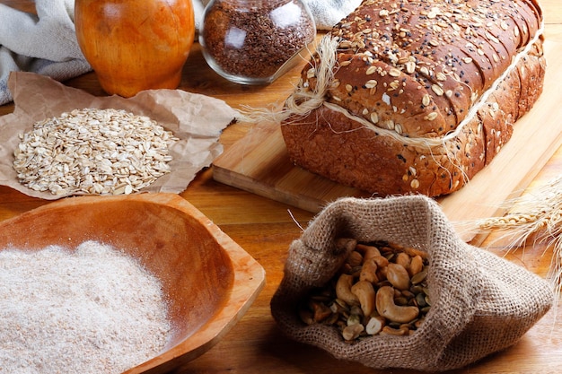 Wholemeal wheat bread or integral bread with grains and seeds sliced on wooden table