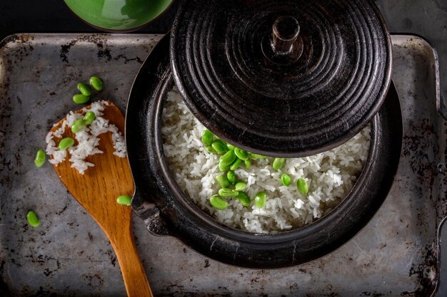 Wholesome Fusion Top CloseUp of Edamame Served on Steamed White Rice in a Cast Iron Pot in 4k