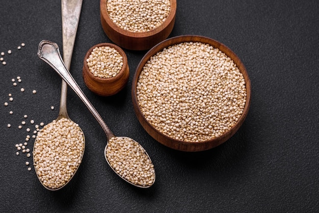 Wholesome raw quinoa in a bowl on a dark concrete background