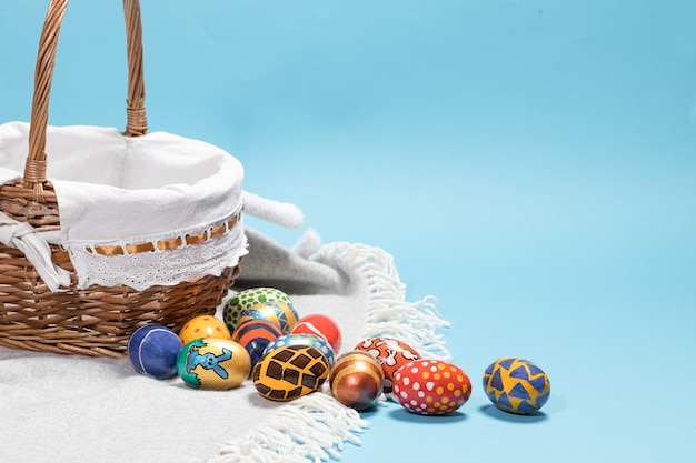 A wicker basket and Easter eggs on a blue background