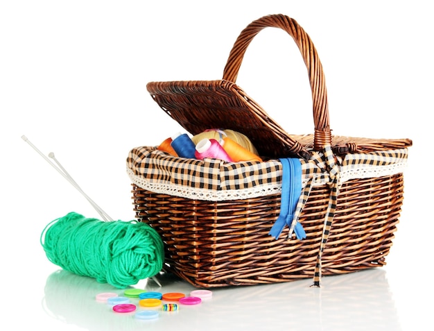 Wicker basket with accessories for needlework isolated on white